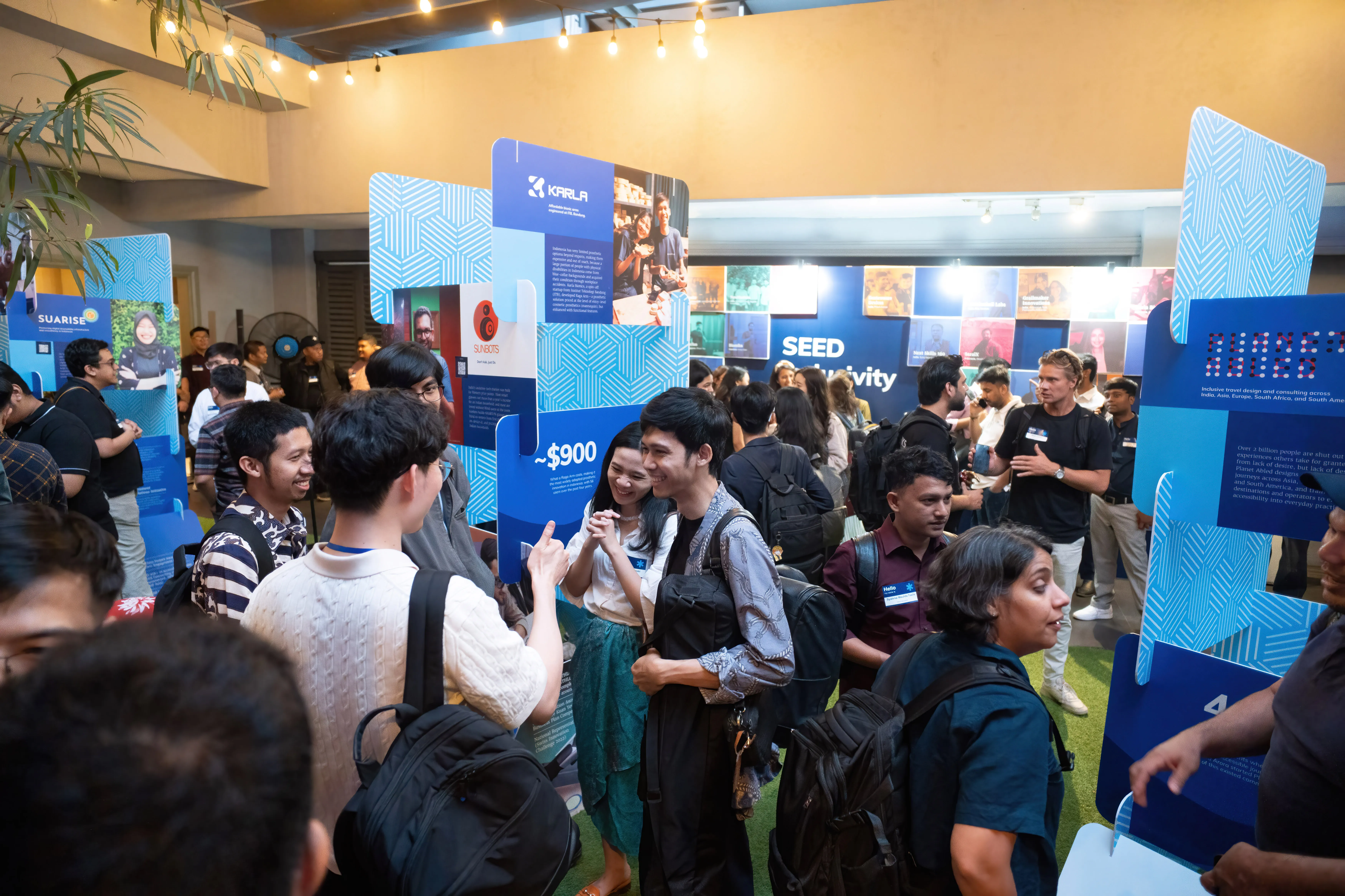 Visitors exploring the SEED Inclusivity gallery exhibition in Jakarta, with venture panels on display